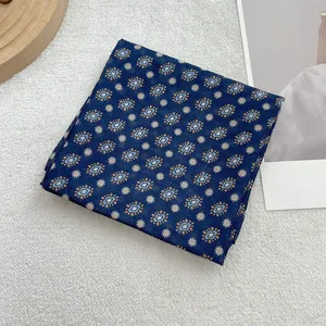 Detail van gevouwen donkerblauwe katoenen sjaal met retro geometrische patronen