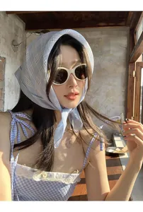 Dettaglio del foulard in cotone a quadretti azzurri con vestito vintage in pizzo
