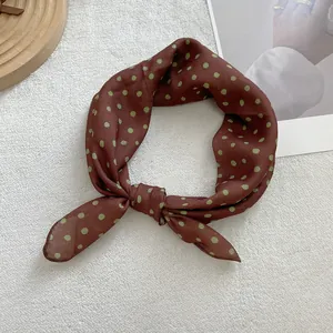 Close-up of brown French polka dot soft scarf with delicate silk-like fabric texture