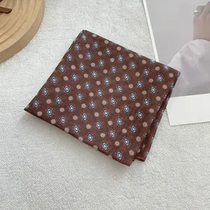 Detail van de katoenen sjaal met blauwe geometrische patronen en oranje bloemenprint