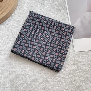 Detail shot of vintage geometric floral pattern scarf with fine black stitched edges