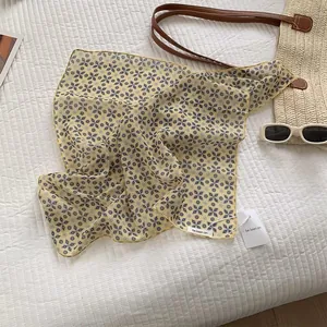 Flat lay of floral cotton linen headscarf with woven bag and stylish sunglasses