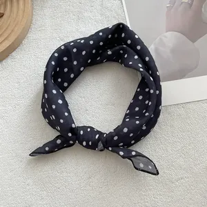 Close-up of black and white polka dot cotton linen neck scarf with soft texture