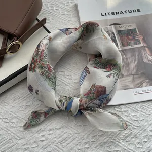 Detail of floral silk scarf with rabbit print on textured fabric with a stylish handbag