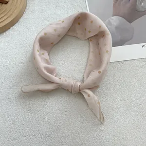 Close-up of pink polka dot cotton linen scarf with elegant rolled edge and decorative knot