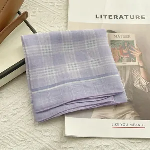Foulard vintage francese in cotone a quadretti viola elegantemente poggiato su libri