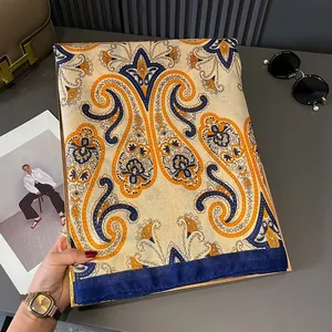 Close-up of elegant silk scarf featuring classic orange and navy paisley patterns