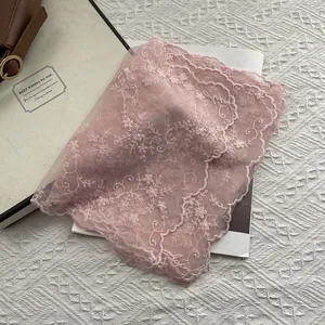 Detailed close-up of pink lace scarf featuring delicate floral embroidery and scalloped edges