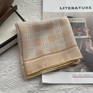 Dettaglio di un foulard di cotone a quadretti giallo caldo con bordi cuciti con precisione