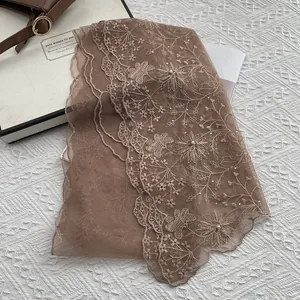 Detail of coffee brown lace scarf with floral embroidery, pearls and rhinestones