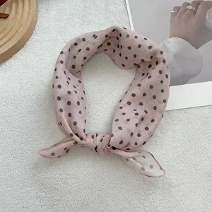 Detail of pink polka dot chiffon scarf with soft fabric texture and stitched edges