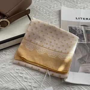 Detail of polka dot bow square scarf with delicate white lace trim on cotton linen fabric