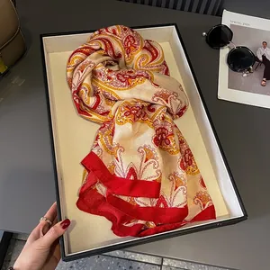 Elegant red paisley printed silk scarf showcased in a premium gift box with spring vibes