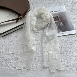 Elegant white lace floral embroidery scarf displayed with stylish fashion accessories