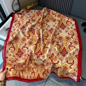 Macro detail of silk-feel paisley print scarf with deep red borders and classic boho pattern