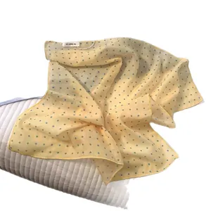 Light yellow linen blend square scarf with blue polka dots and branding label