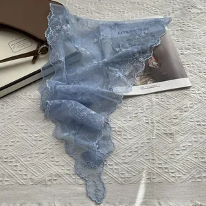 Détail d'un bandeau triangle en dentelle bleu clair avec broderie florale blanche