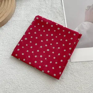 Close-up of red and white polka dot cotton linen square scarf on aesthetic background