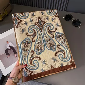 Detail of bohemian paisley scarf with brown borders shown in a gold frame setting