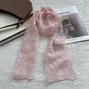 Close-up of pink floral lace scarf with embroidery and delicate scalloped edges