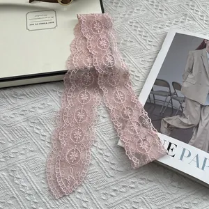 Detail of pink floral lace scarf with Love embroidery on a white textured background