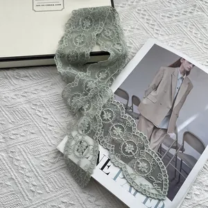 Detailed close-up of sage green floral lace scarf with embroidery and scalloped edges