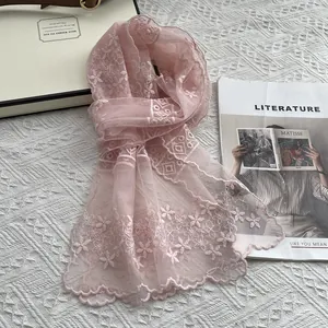 Detailaufnahme des hellrosa Spitzenschals mit Stickerei, Blumenmuster und Wellensaum