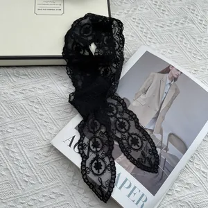 Close-up of elegant black lace scarf with hollow floral embroidery and scalloped edges
