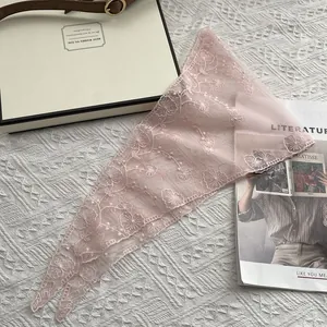 Detail of pink lace triangle headscarf with delicate floral embroidery and mesh texture