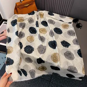 Close-up of beige linen scarf featuring irregular colorful polka dots and gold foil details
