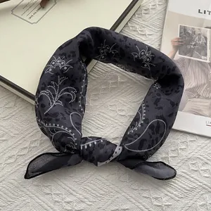 Detail of dark gray paisley bandana with leopard and floral prints on textured fabric
