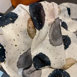Detail showing beige cotton linen fabric with ink dots and golden foil accents