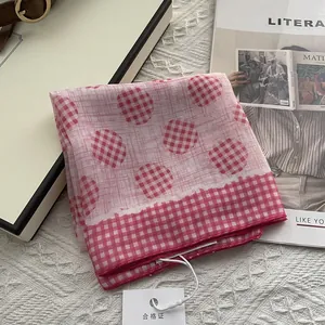 Detail of pink and white checkered cotton square scarf with dot pattern and tag