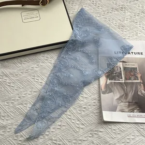 Detailed close-up of sky blue lace triangle bandana featuring delicate floral embroidery