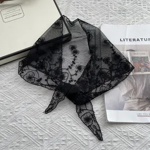 Detail showing delicate black floral embroidery on a sheer lace triangle headscarf