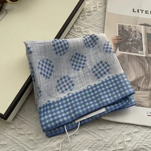 Detail of blue and white checkered cotton handkerchief with dots and tag on a book