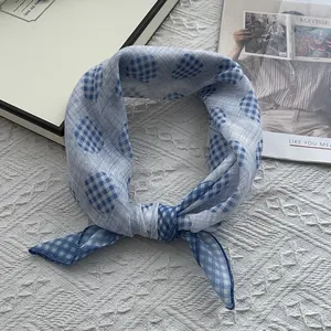 Detail of blue and white checkered scarf with polka dots on a textured fabric