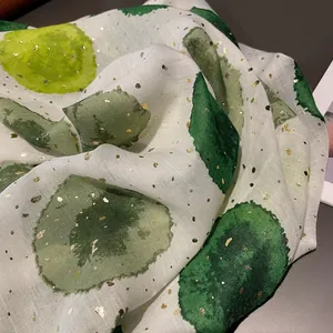 Detail of green watercolor polka dot scarf with delicate gold foil accents on cotton linen