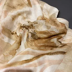 Detailed close-up of golden sequins on iris printed cotton linen scarf fabric with soft folds