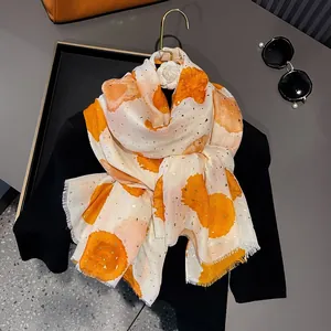Detail of beige cotton-linen scarf with orange watercolor dots and gold foil embellishments