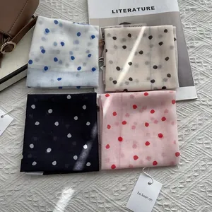 Polka dot silk scarf set in four colors with gift tags on a stylish knit background