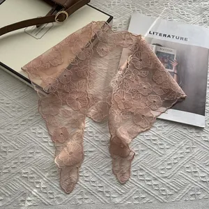 Detailansicht eines eleganten blassrosa Spitzenschals mit feiner floraler Stickerei-Textur