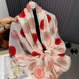 Detail of beige cotton linen scarf featuring red polka dots and gold foil sparkles