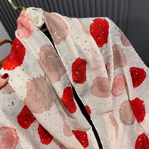 Detail of beige cotton linen scarf featuring red polka dots and gold foil embellishments