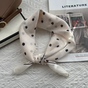 Detailed close-up of soft polka dot square scarf with premium knotted texture and trim