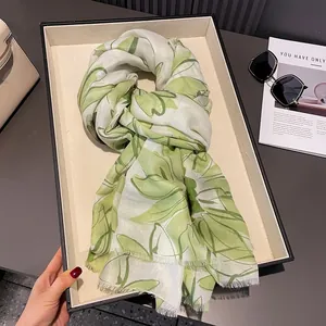 Elegant green floral cotton linen scarf with tassels, ideal as a beach shawl or wrap