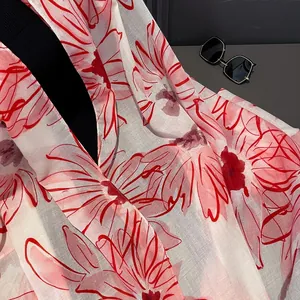 Detailed texture of lightweight cotton scarf with red floral prints and stylish sunglasses