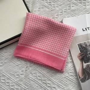 Detailopname van roze geruite katoenen vierkante sjaal met fijne textuur en rand