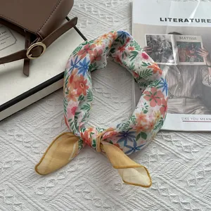 Foulard fleuri en coton et lin avec imprimé coloré et ourlet jaune sur fond texturé