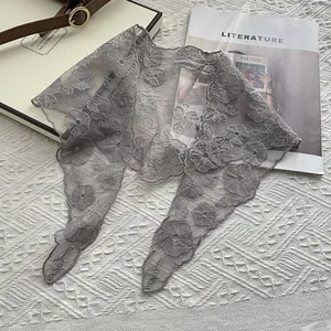 Detail eines grauen Spitzen-Schals mit feiner 3D-Blumenstickerei auf Netzstoff